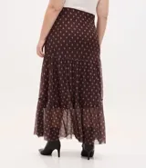 Falda midi de tul con estampado de corbatas, cintura elástica y diseño con volados. Presenta un forro más corto que crea un efecto de transparencia en el ruedo.