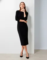 Vestido negro de seda fría, corte midi, con escote barco y mangas tres cuartos. Presenta frunces drapeados en la zona de la cintura y cadera.