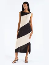 Vestido largo de tejido de punto con diseño bicolor a rayas diagonales en negro y beige, sin mangas, con escote bote y tajo lateral.