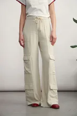 Pantalón cargo color beige de corte ancho, con bolsillos laterales y cordón ajustable en la cintura.