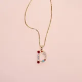 Collar dorado con dije de la letra D adornado con cristales de colores.