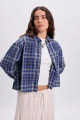 Camisa de manga larga con estampado a cuadros en tonos azules, cuello camisero y cierre frontal con botones.