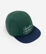 Gorra de estilo urbano confeccionada en tejido fleece, con paneles estructurados en color verde y visera curva en color azul marino. Presenta un bordado frontal con lettering en color blanco.