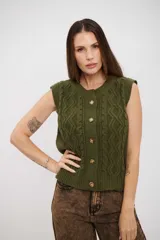Chaleco de tejido de punto color verde oliva, con diseño de trenzas, cuello redondo y cierre frontal con botones.