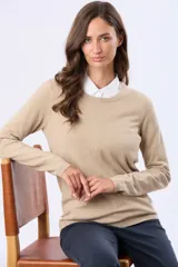 Buzo tejido de hilo de algodón color beige, de manga larga y cuello redondo clásico.