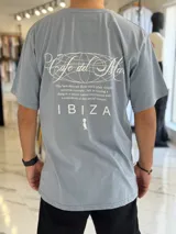 Remera oversize color celeste, con diseño gráfico estampado en la espalda que incluye texto y la inscripción "Ibiza".