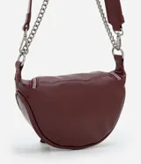 Cartera tipo riñonera de tamaño pequeño, confeccionada en poliuretano con acabado brillante. Presenta un diseño de media luna con cierre de cremallera metálica, decorado con tiradores circulares. Incluye una correa de cadena metálica para llevar al hombro o cruzada.