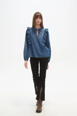 Blusa de jean con volados frontales, cuello redondo con abertura en V y lazo para anudar, y mangas largas con puños elásticos.