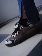 Championes de gamuza azul marino con detalles de estampado animal print de leopardo, cordones azules y suela de goma.
