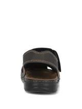 Sandalias de cuero color marrón oscuro con diseño tipo huarache o romano, costuras visibles en tono contrastante y cierre con tira ajustable de velcro en el empeine.