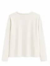 Remera de algodón con spandex, color negro, de manga larga y ajuste al cuerpo. Presenta un escote redondo con cartera frontal de botones y detalle de cordón decorativo en contratono.