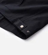 Campera tipo trucker de sarga color azul marino, con cuello de terciopelo al tono, cierre frontal de cremallera y bolsillo con cierre en el pecho.