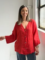 Camisa oversize de lino color rojo, con escote en V, mangas largas amplias y cierre frontal con botones.