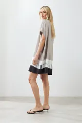 Vestido camisero color beige con detalle de teñido tie dye en blanco y negro en el ruedo.