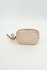 Neceser acolchado color beige con diseño de carita feliz bordada en el frente y cierre superior con tirador de cordón.