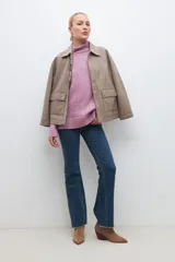 Sweater de punto buclé color gris melange, con cuello alto y mangas largas.