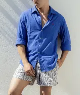 Camisa de lino azul francia de manga larga con cuello clásico y logo bordado en rojo.