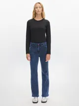 Jean de mujer, corte flare, tiro medio, confeccionado en denim azul oscuro con efecto lavado (acid wash) y terminación desflecada en el ruedo.