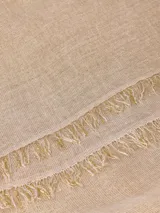 Bufanda de estilo clásico color gris claro, con detalles de flecos cortos en los extremos. Tejido suave y cálido.