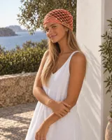 Gorro de red tejido color tostado, con diseño artesanal, lentejuelas incorporadas que aportan brillo y una etiqueta frontal de cuerina con la marca grabada.