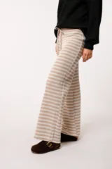 Pantalón tejido a rayas horizontales negras y grises, con forro interior y cordón ajustable en la cintura.