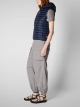 Chaleco acolchado ligero color gris topo, con capucha y cierre frontal. Confeccionado con relleno sintético Plumtech.