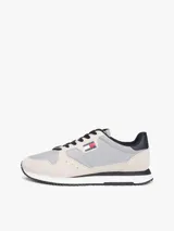 Zapatillas runner Tommy Jeans Eva de estilo urbano, confeccionadas con una combinación de textil, cuero y material sintético en tonos gris, beige y negro. Cuentan con cordones negros, suela bicolor y detalles de la marca.