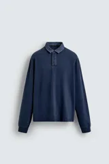 Sudadera polo azul marino de corte regular fit, con cuello solapa en contraste y cierre frontal de botonadura oculta. Tiene manga larga con puños acanalados y un efecto lavado.