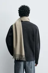 Jersey de punto con textura, corte relajado, cuello redondo y manga larga con acabados en rib.