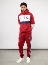 Pantalon de jogging azul de felpa, con franjas laterales en blanco y azul marino. Presenta el escudo del Club Nacional de Football en el muslo derecho y el logo de Umbro en el izquierdo.