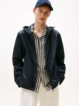 Campera con capucha de poliéster reciclado, color azul marino, con cierre frontal de cremallera. Presenta detalles en los colores de la marca (RWB) y un logo engomado de Tommy Hilfiger en la manga.