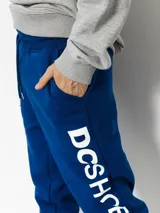 Pantalón de jogging azul con cordón ajustable en la cintura y gran estampado vertical de la marca en la pierna izquierda.