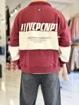 Buzo de cuello polo y medio cierre, con diseño de bloques de color en gris y blanco, de corte oversize y mangas largas.
