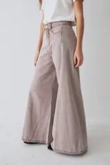 Pantalón de jean azul de tiro alto y corte wide leg súper amplio, con diseño de perneras ancha y terminación desmechada en el ruedo.
