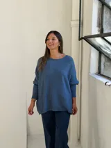 Sweater de punto color azul, con cuello redondo, corte holgado y mangas largas con puños ajustados.