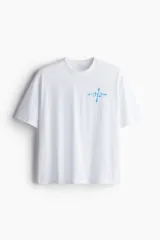 Remera deportiva de corte holgado con hombros caídos y cuello redondo acanalado. Confeccionada en tejido funcional con tecnología DryMove que absorbe el sudor. Presenta un pequeño estampado gráfico en color azul en el pecho.