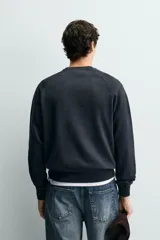 Sudadera regular fit color azul, de cuello redondo, manga larga ranglán y efecto lavado con acabados en rib.