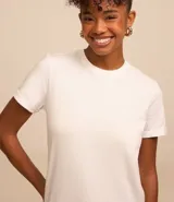 Remera tipo t-shirt de algodón, color beige claro, con cuello redondo y mangas cortas dobladas.