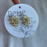 Par de caravanas doradas con forma de estrella con incrustaciones de strass.