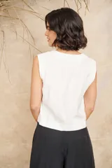 Chaleco negro con escote en V y cierre frontal con tres botones dorados.