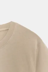 Camiseta de algodón color beige con efecto lavado, cuello redondo y mangas cortas de corte regular fit.