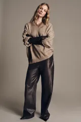 Jersey oversize color beige melange, confeccionado con lana, con cuello en V y manga larga.