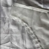Conjunto de lencería de dos piezas color blanco, confeccionado en tela suave y semitransparente con detalles de encaje en los bordes. Incluye un bralette triangular sin aro ni relleno, con breteles regulables y una bombacha vedetina a juego.