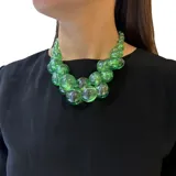 Collar de cuentas esféricas de resina translúcida color verde, con cierre de mosquetón y cadena dorada para regular el largo.