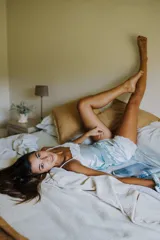 Pijama de satén elastizado color champagne, compuesto por musculosa con escote en V y detalle de puntilla elastizada, y short con elástico en la cintura y terminación con puntilla.