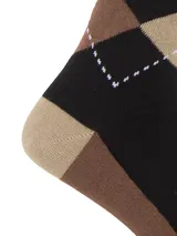 Media de largo medio con diseño de rombos en tonos negro, marrón y beige. Presenta un pequeño bordado de un perro en el centro y puntera y talón en color contrastante.