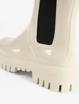 Botas de lluvia de caña media con acabado brillante, diseño tipo chelsea con paneles laterales elásticos en color negro y suela track dentada de plataforma.