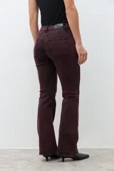 Pantalón de jean tiro alto, color bordó con efecto acid wash, corte oxford (acampanado en la parte inferior).