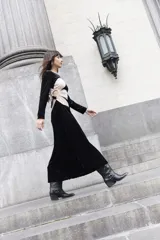 Vestido largo de terciopelo negro con corte en la cintura y detalle cut-out en la espalda.