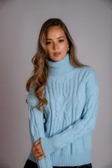 Suéter tejido de punto trenzado color salmón, con cuello alto y mangas largas. Corte ajustado al cuerpo.